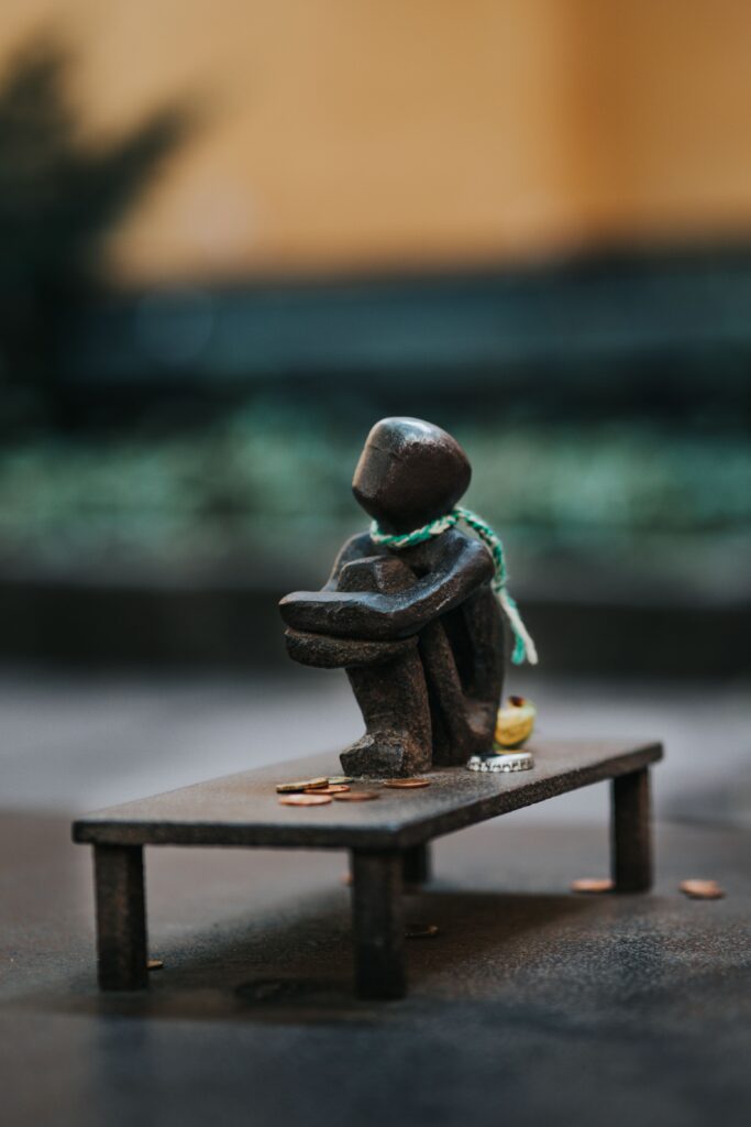 Decorative small cast iron statue sitting outdoors on a wooden surface